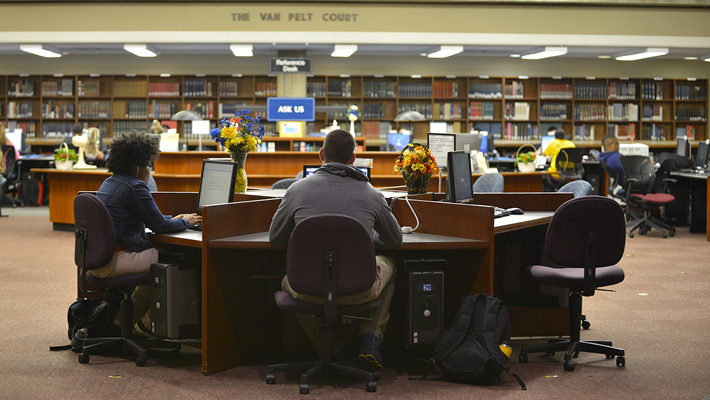Students studying at a table in the center of Wolfgram Memorial Library
