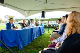 Students sit and listen to a panel of business faculty and alumni