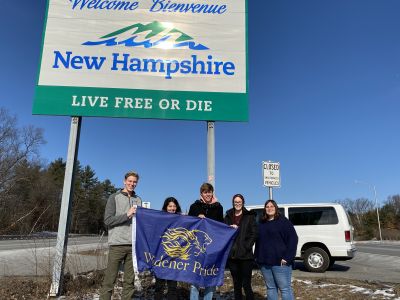Students pose in front of the New Hampshire sign