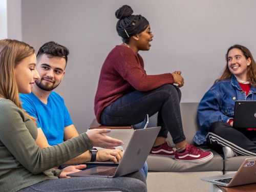 Students in residence hall lounge studying with each other